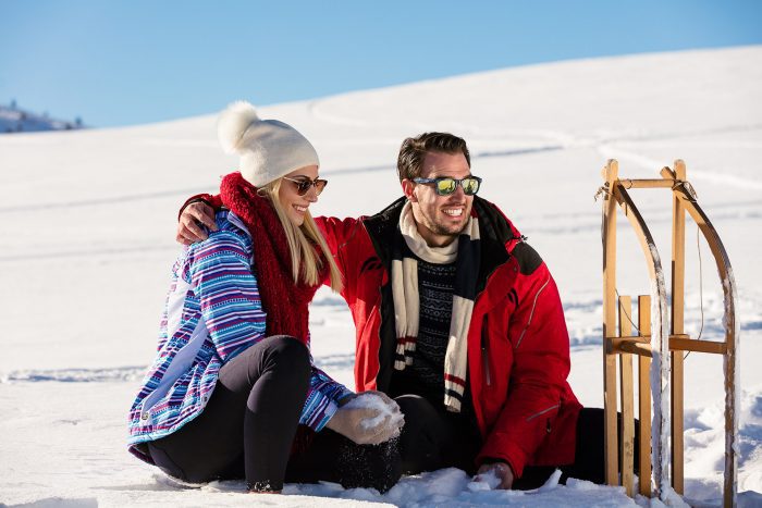 Hotel Alpenhof, Winterzeit, Rodeln, Paar im Schnee